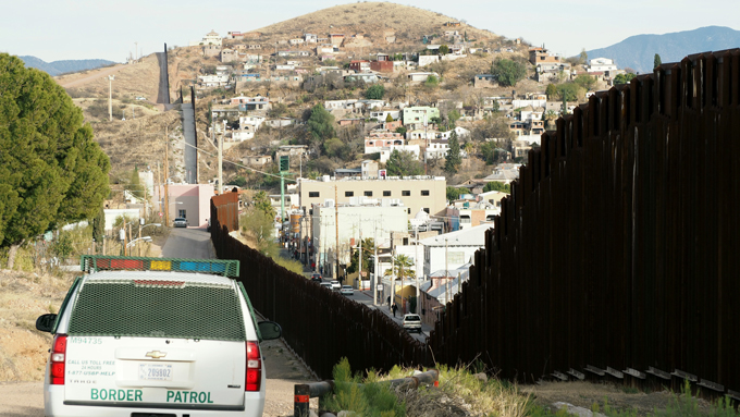 米アリゾナ州ノガレスから見た対メキシコ国境に設置された高さ６メートルの鉄柵の壁。よじ登って米国に侵入する移民の姿を「ほぼ毎日」目撃している住民たちは、トランプ大統領の壁建設令にも冷ややかな視線を向けて暮らしている＝20170203-　写真提供：時事通信