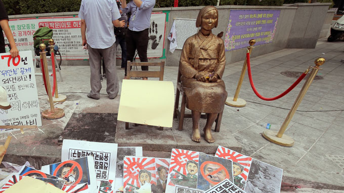 抗議活動のプラカードなどが散乱するソウルの日本大使館建物前の慰安婦像＝2015年08月15日韓国・ソウル　写真提供：産経新聞社