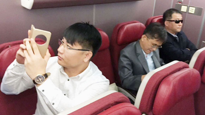 マレーシアから北京へ向かう機内で記者がキム・ウクイルさんかと問うと男性(左)は「違います」と答えた=20170330クアラルンプール　写真提供：共同通信社