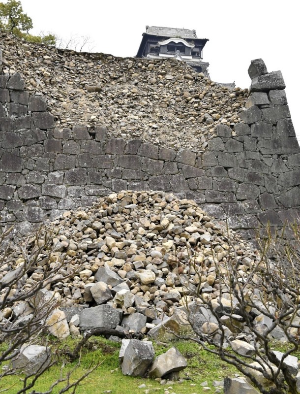 熊本地震で崩れた熊本城の石垣。上は天守閣　写真提供：共同通信