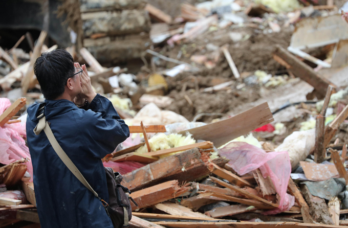 土砂崩れ 住宅地 西日本豪雨被害 遺体 手を合わせる