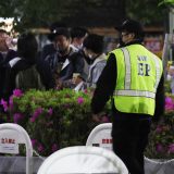 多くの人が集まった新橋駅近くの公園では、警備員（左手前）が密を避けるよう呼び掛けていた＝2021年4月16日午後8時24分、東京都港区　写真提供：時事通信社