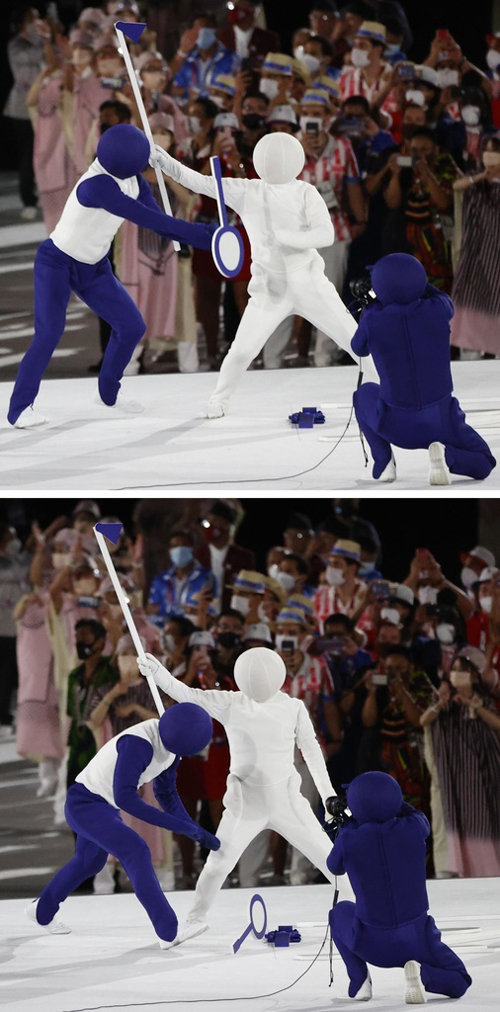 東京五輪の開会式で、ピクトグラムと同じポーズをとるパフォーマー。バドミントンのラケットを落として失敗？　撮影：2021年07月24日　写真提供：共同通信社