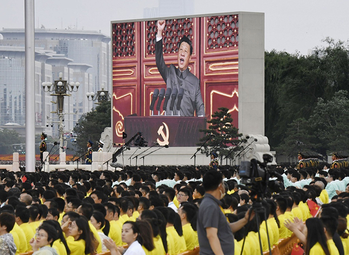 中国共産党創建100年を記念する祝賀大会で、大型スクリーンに映し出された「中国共産党万歳」と叫んで拳を突き上げる習近平国家主席＝2021年7月1日、北京の天安門広場（共同）　写真提供：共同通信社