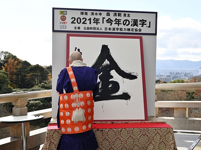 2021年の世相を1字で表す「今年の漢字」が「金」に決まり、京都・清水寺で森清範貫主が力強く揮毫（きごう）した＝2021年12月13日午後（代表撮影）　写真提供：共同通信社