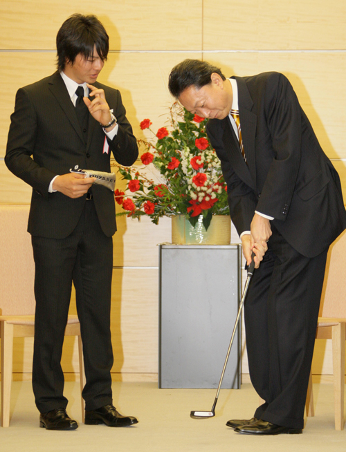 日本プロスポーツ大賞を受賞したプロゴルファーの石川遼選手（左）から贈られたパターを手にする鳩山由紀夫首相　＝2009年12月25日午前11時13分、首相官邸 　写真提供：産経新聞社