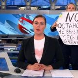 ロシア政府系テレビのニュース番組で、「戦争反対」のメッセージを掲げる女性スタッフ（ロシア）　AFP＝時事　写真提供：時事通信