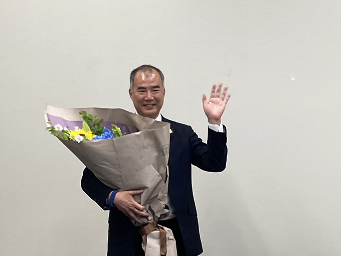 職員から花束を渡され、笑顔で手を振る野口聡一さん（5月25日撮影）