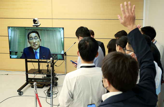 首相公邸からオンラインで取材に応じる岸田文雄首相（モニター画面）に挙手する記者ら＝2022年8月24日午後、首相官邸　写真提供：時事通信社