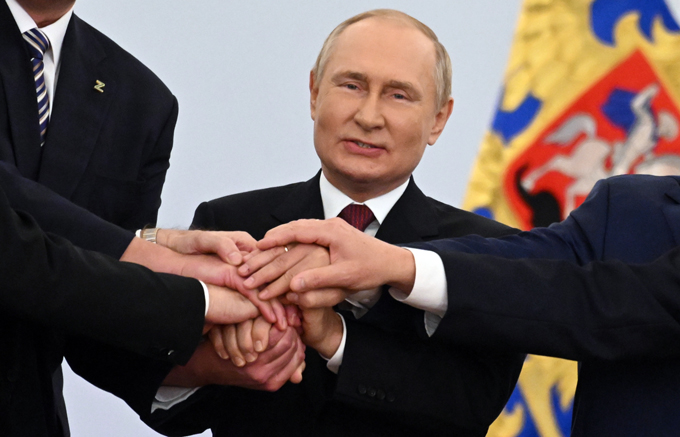 モスクワのクレムリン（ロシア大統領府）で、「編入条約」調印を親ロシア派幹部と喜ぶプーチン大統領　Grigory Sysoev / Sputnik / 時事通信フォト