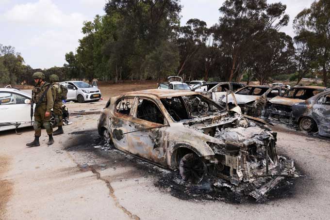 イスラム組織ハマスの襲撃で多数が犠牲となった音楽フェスティバルの会場近くに残された車＝2023年10月10日、イスラエル南部（ロイター＝共同）