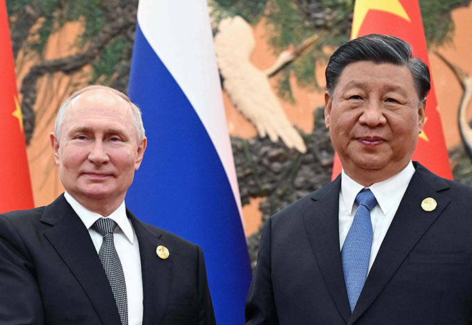 北京で握手を交わすロシアのプーチン大統領（左）と中国の習近平国家主席（中国・北京）＝2023年10月18日　AFP＝時事　写真提供：時事通信