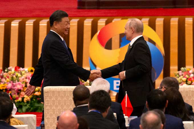 握手する中ロ首脳　北京で開かれた「一帯一路」国際協力サミットフォーラムで握手する中国の習近平国家主席（左）とロシアのプーチン大統領（中国・北京）　撮影日：2023年10月18日　EPA＝時事
