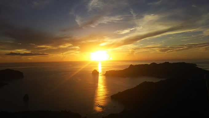父島の傘山から望む二見湾と水平線に沈む夕日