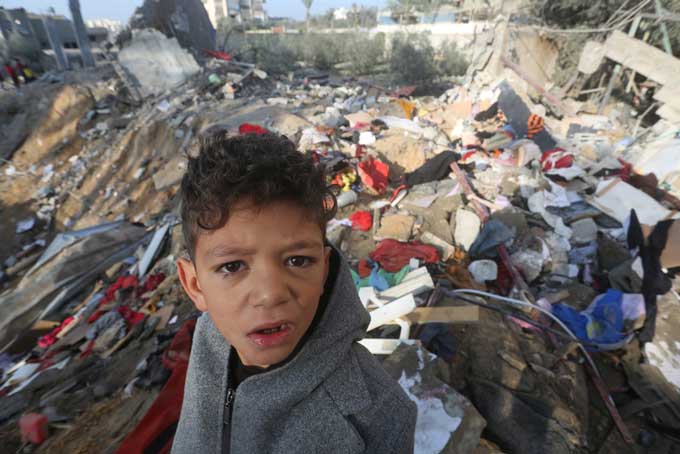 GAZA, Dec. 12, 2023 (Xinhua) -- A boy is seen among the rubble of a building destroyed in an Israeli airstrike in the southern Gaza Strip city of Rafah, on Dec. 12, 2023. The Ministry of Health in the Gaza Strip announced on Tuesday that the Palestinian death toll in the Palestinian enclave has exceeded 18,400 since the eruption of the Hamas-Israel conflict on Oct. 7. (Photo by Khaled Omar/Xinhua)＝ 新華社／共同通信イメージズ