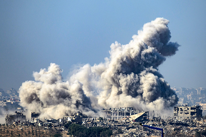イスラエル軍の空爆を受け、パレスチナ自治区ガザの建物から上がる煙。＝2023年12月1日　AFP＝時事　写真提供：時事通信