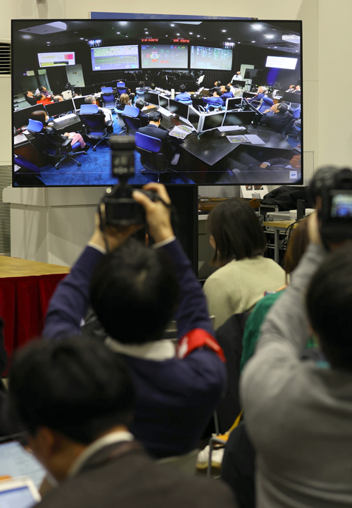 JAXA相模原キャンパスの記者会見場に映し出された、管制室で小型月着陸実証機（SLIM）の月着陸を見守る関係者ら＝2024年1月30日午前、神奈川県相模原市（松井英幸撮影）　写真提供：産経新聞社