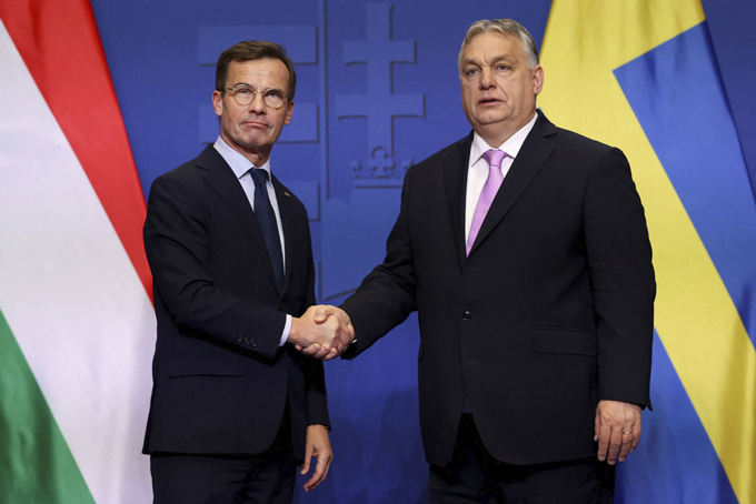 ハンガリーの首都ブダペストで、握手するスウェーデンのクリステション首相（左）とハンガリーのオルバン首相＝2024年2月23日（ロイター＝共同）