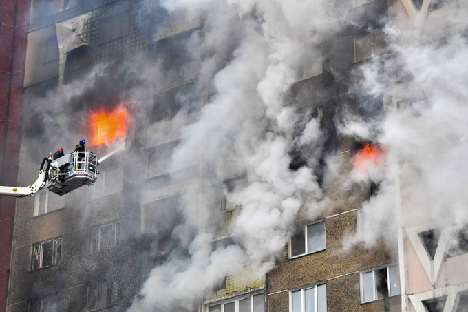 ミサイル攻撃のあったキーウ（キエフ）で、集合住宅の消火活動に当たる救急隊員（ウクライナ・キーウ）撮影日：2024年02月07日　AFP=時事