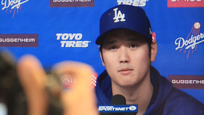 The Los Angeles Dodgers' Shohei Ohtani delivers a statement during a closed press conference as seen on a TV in the press box at Dodger Stadium in Los Angeles on March 25, 2024. Los Angeles Dodgers superstar Shohei Ohtani denied ever betting on baseball or other sports on March 25 in his first public comments since a scandal involving his long-time interpreter erupted last week.　DAVID SWANSON / AFP　AFP＝時事　写真提供：時事通信