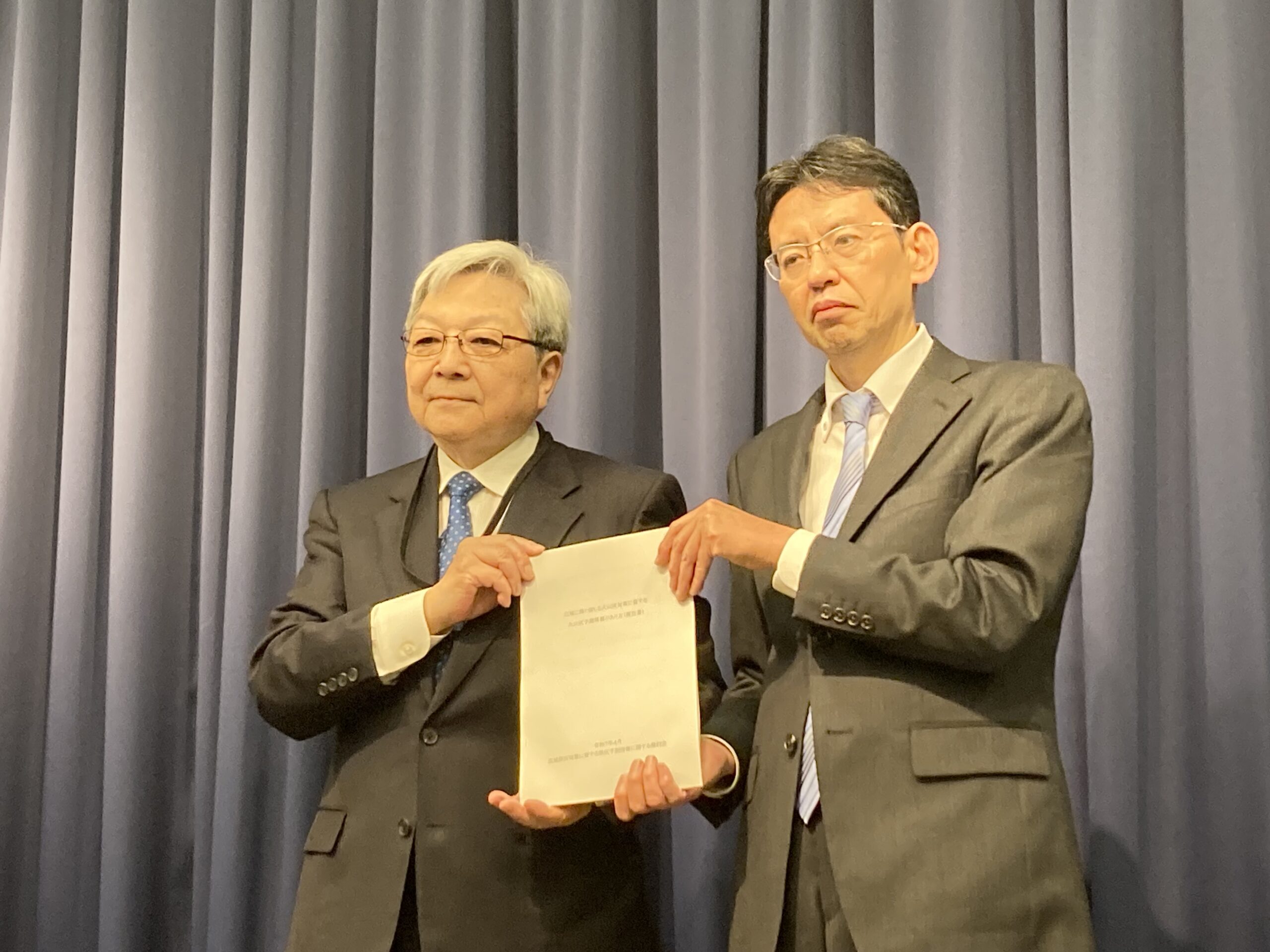 気象庁検討会の藤井座長(左)から報告書が手交された(2025年4月25日)