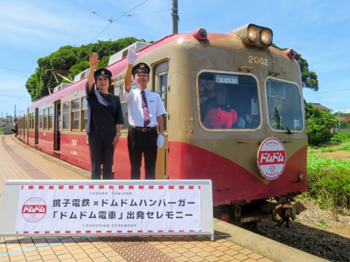 犬吠駅で「ドムドム電車」に出発の合図を送る銚子電鉄 西上社長(右)ドムドムフードサービスの藤﨑社長